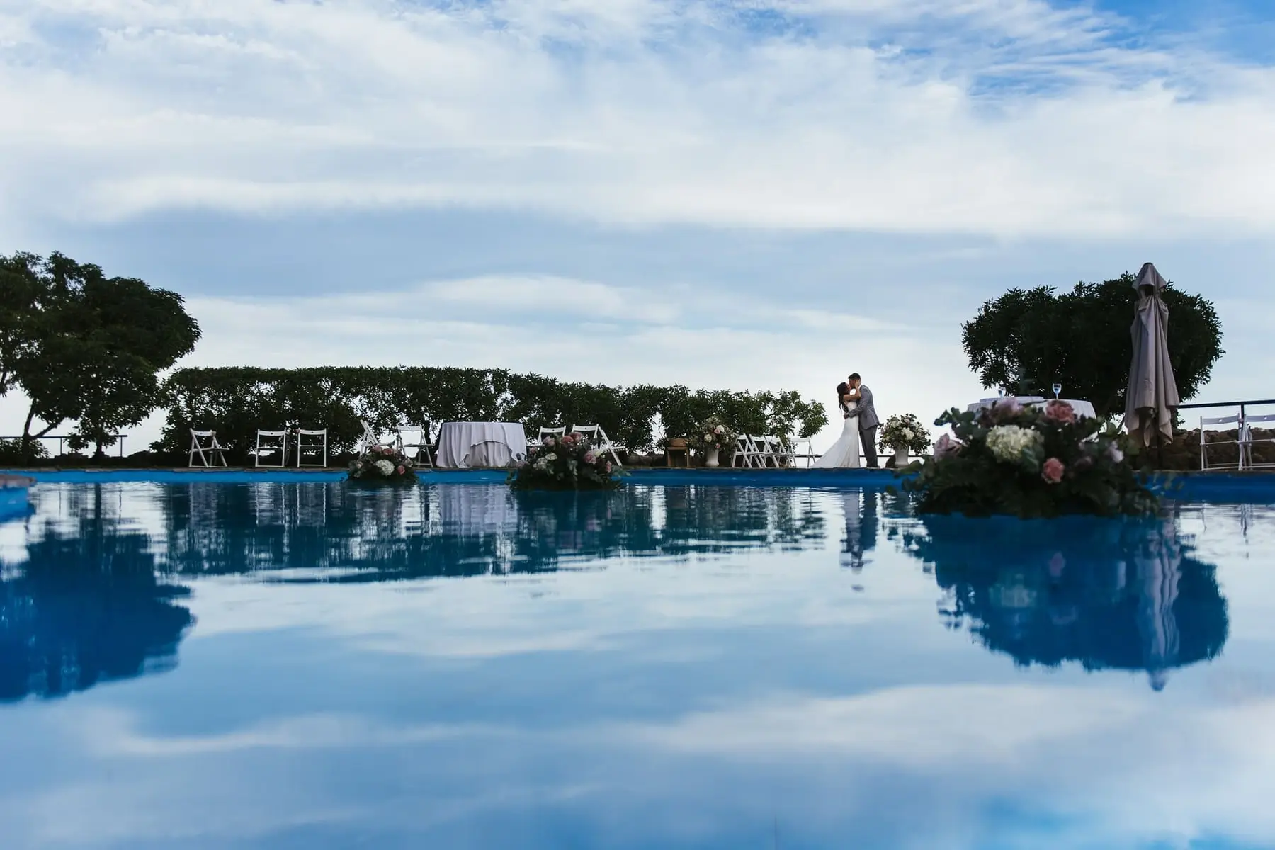 The pool mirrors the sky and the couple in the garden