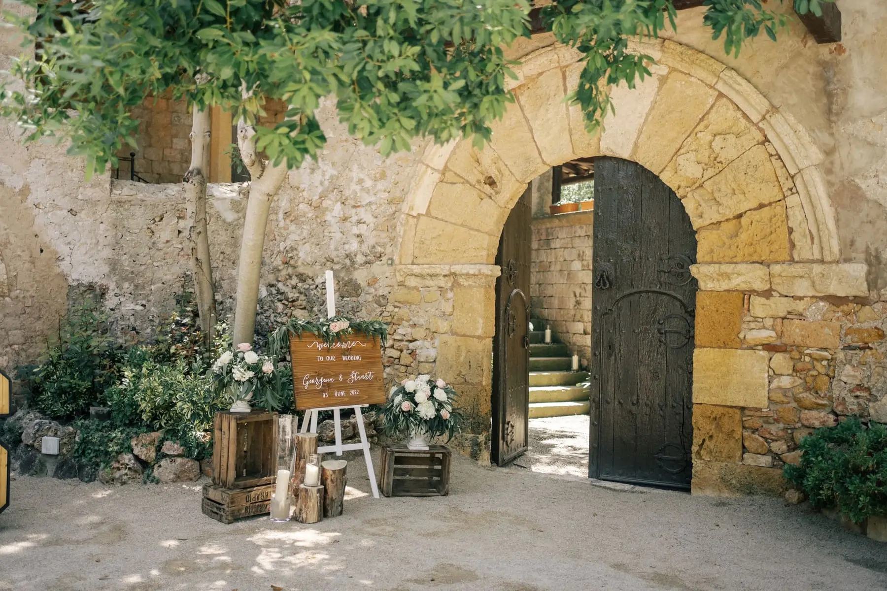 An arched wooden door dressed for the wedding