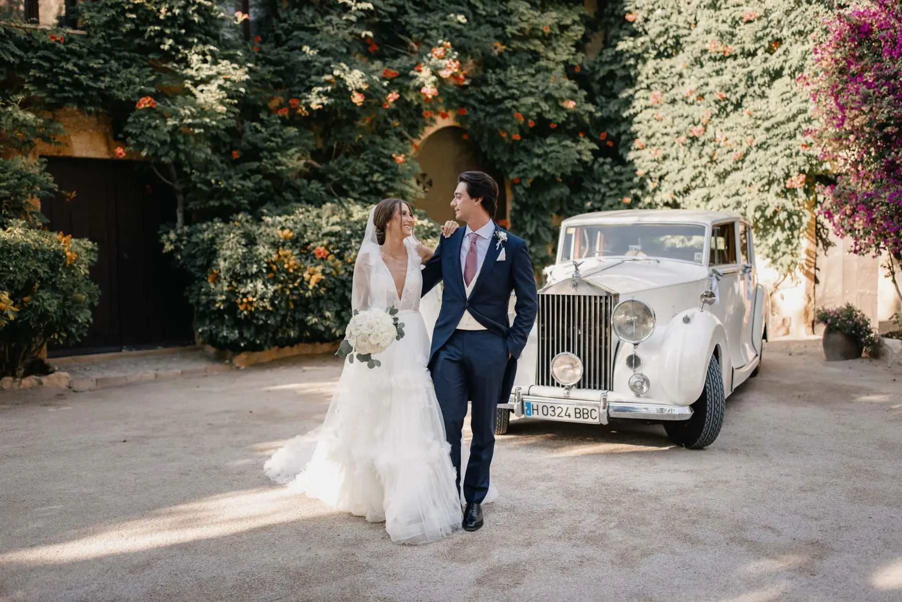 The couple arrive by classic Rolls-Royce among the ivy